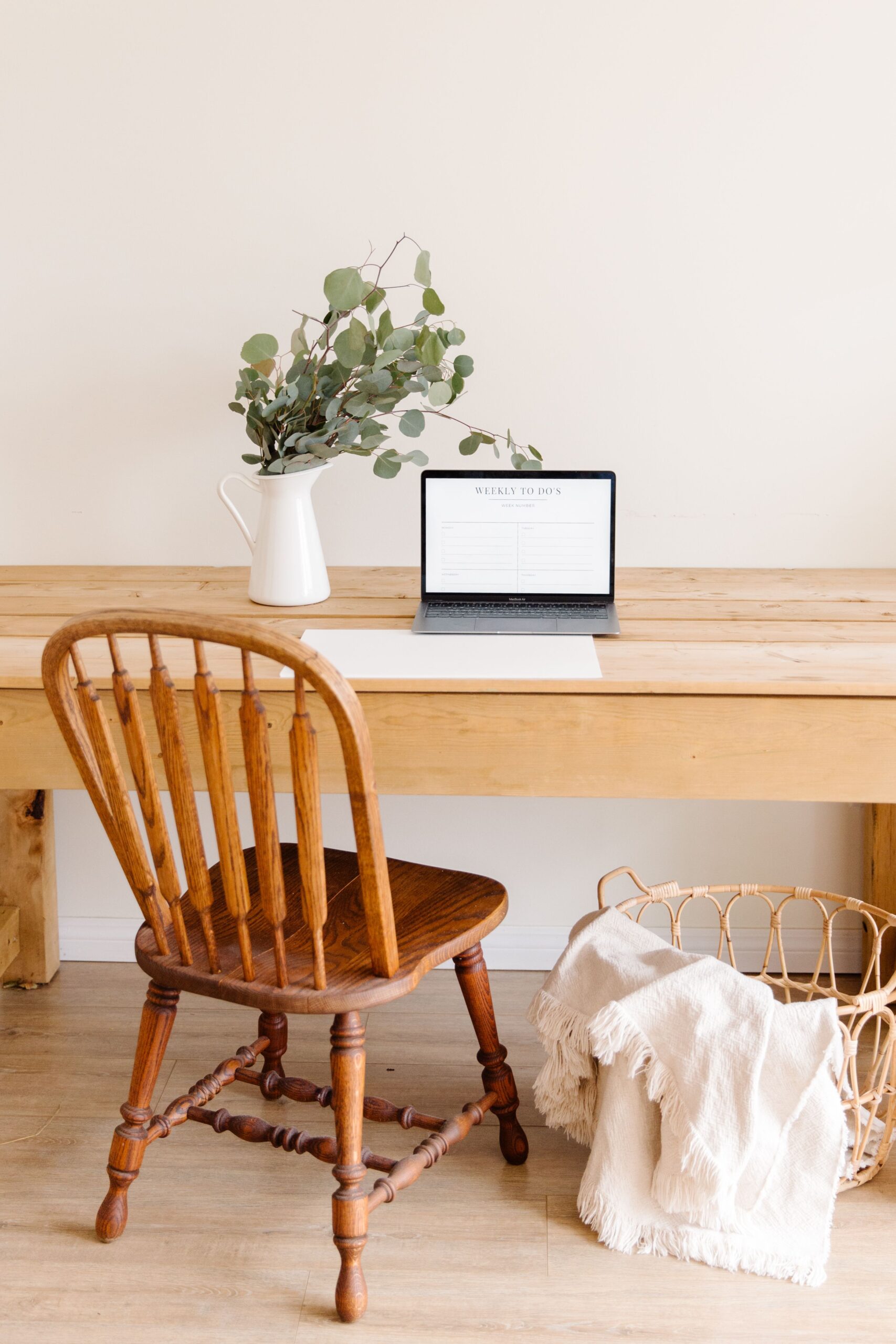 Small wooden desk with a laptop and flowers